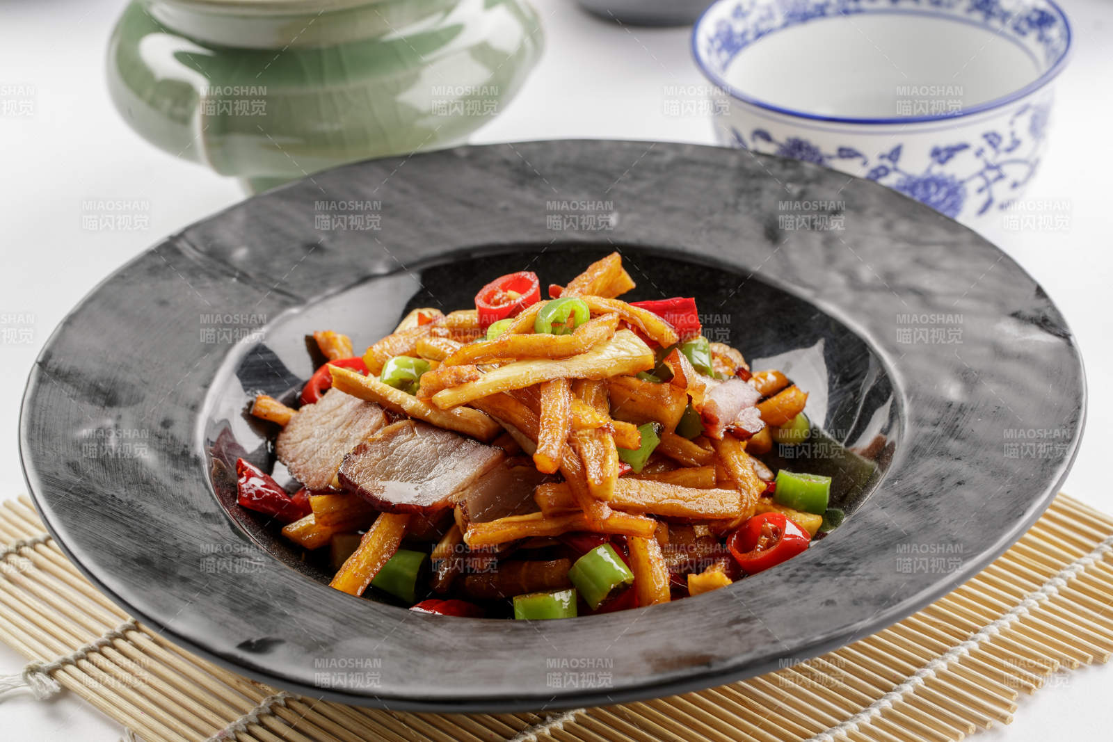 黑色石盘装的菜菔炒腊肉