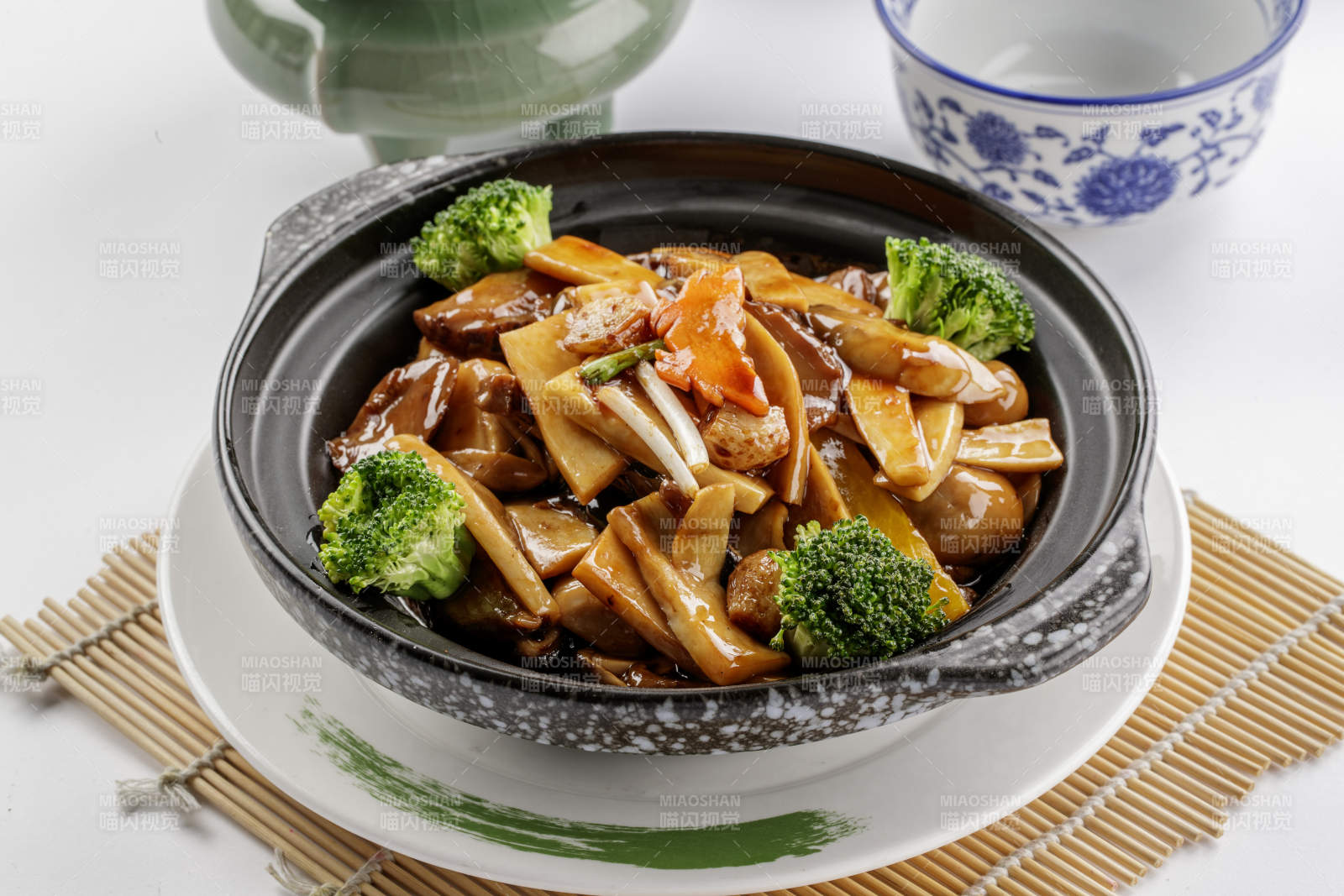 黑色砂锅装的鲍汁煲杂菌-摄影图