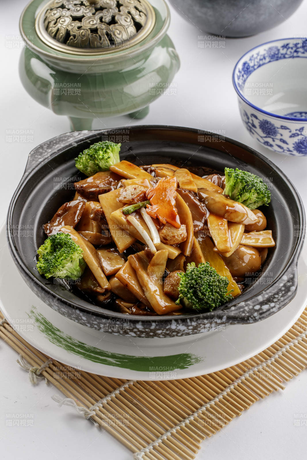 黑色砂锅装的鲍汁煲杂菌-摄影图