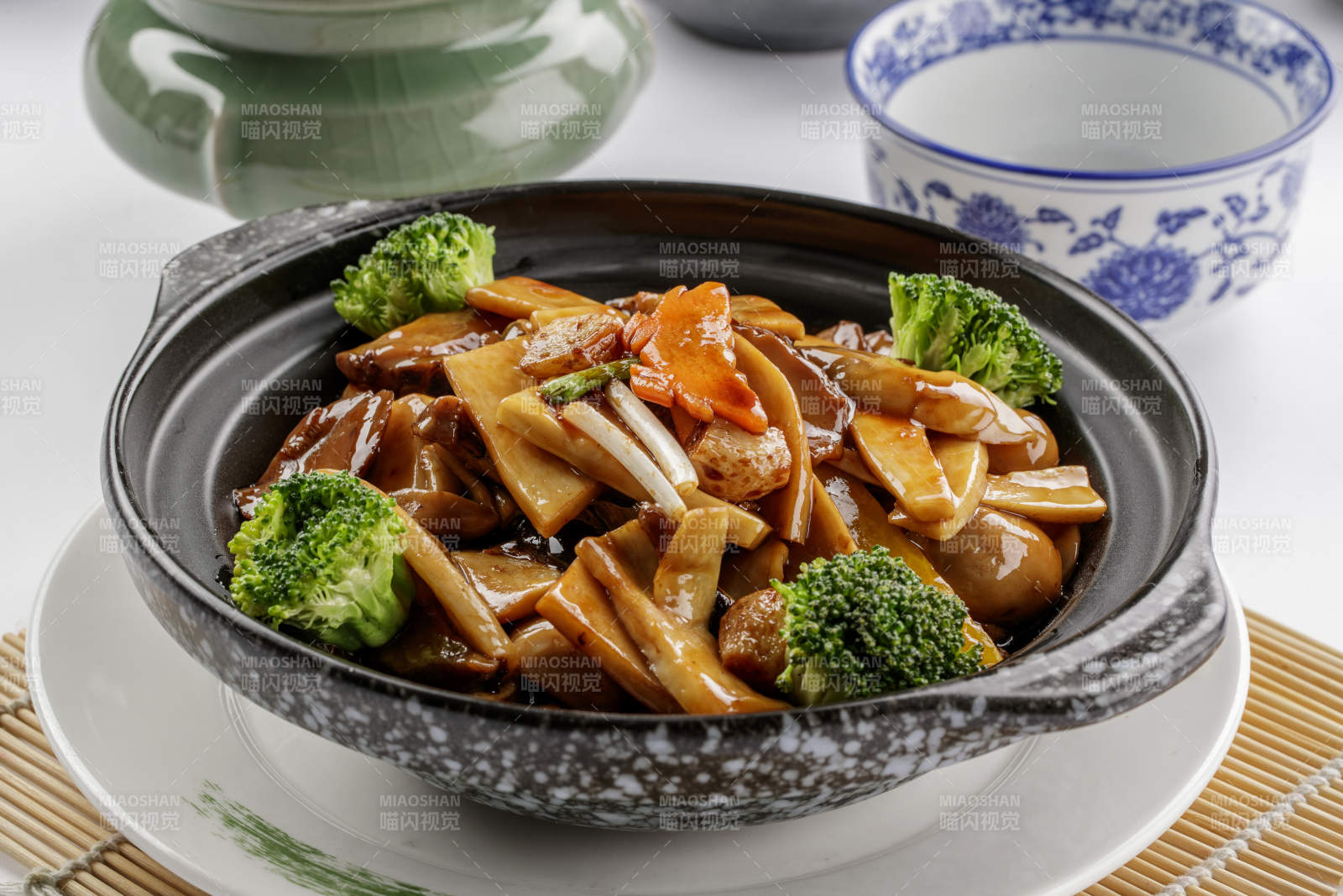 黑色砂锅装的鲍汁煲杂菌-摄影图