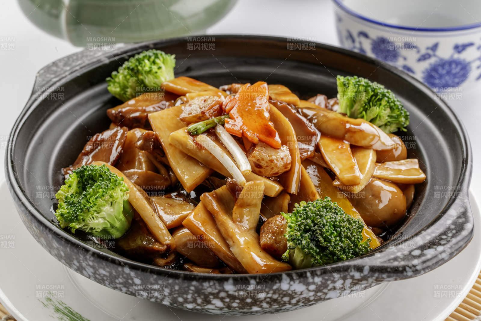 黑色砂锅装的鲍汁煲杂菌-摄影图