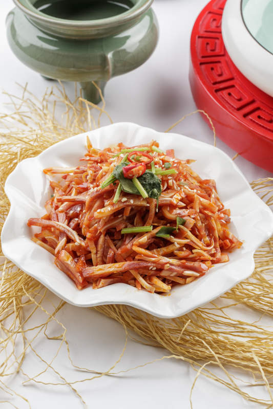 白色瓷盘装的凉拌猪耳