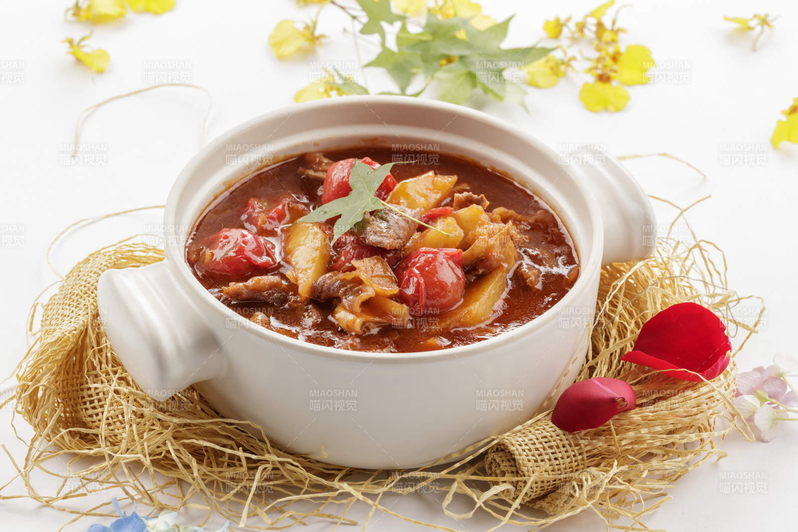 白色砂锅装的番茄土豆炖牛腩