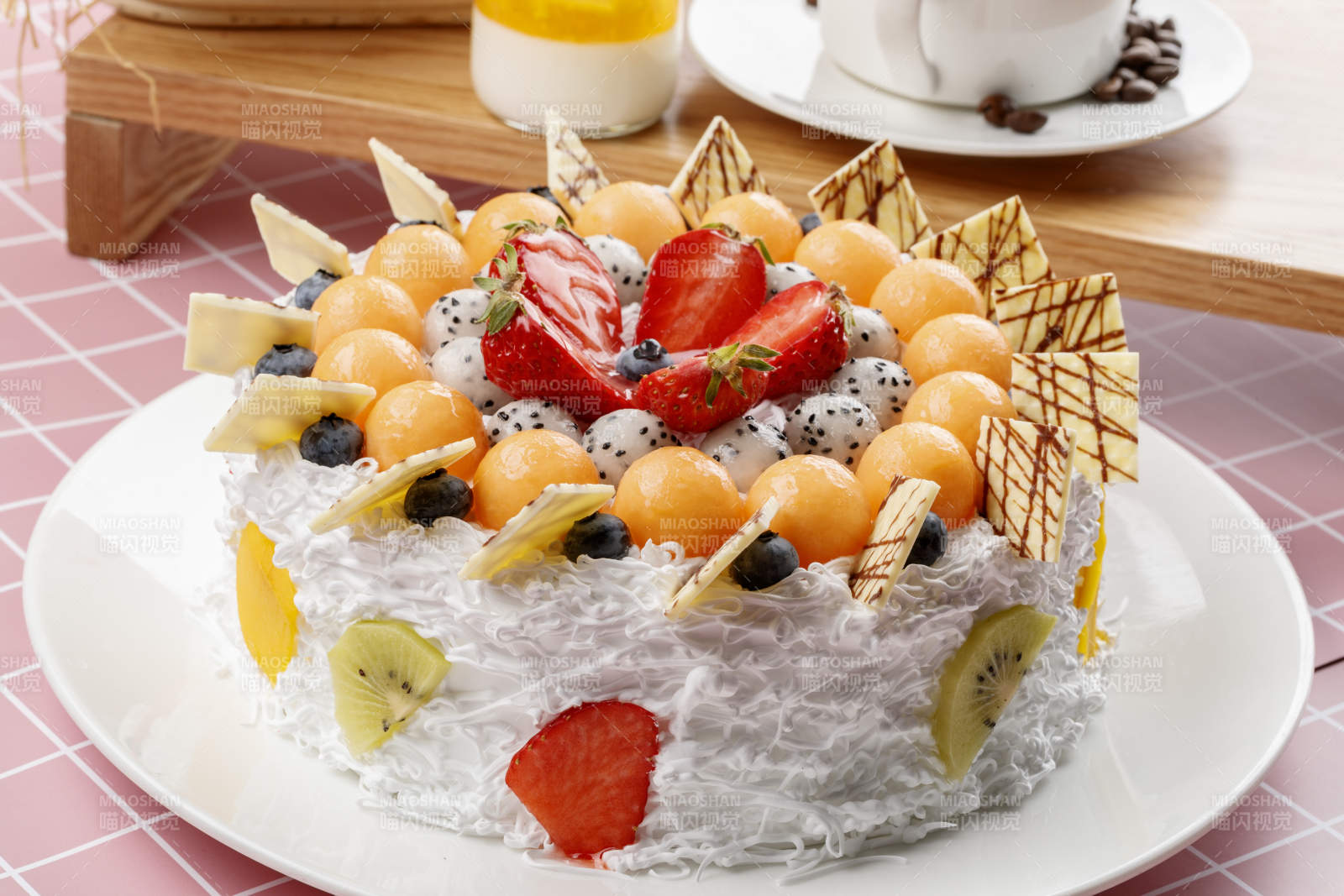 奶油缤纷水果蛋糕摆放在粉色背景上