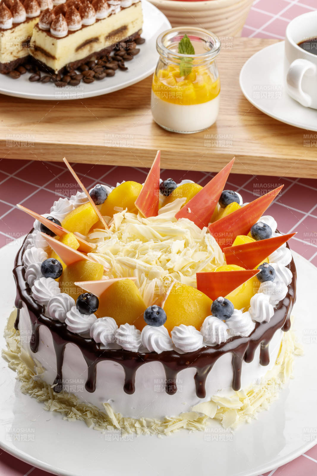 芝士水果奶油巧克力蛋糕摆放在粉色背景上