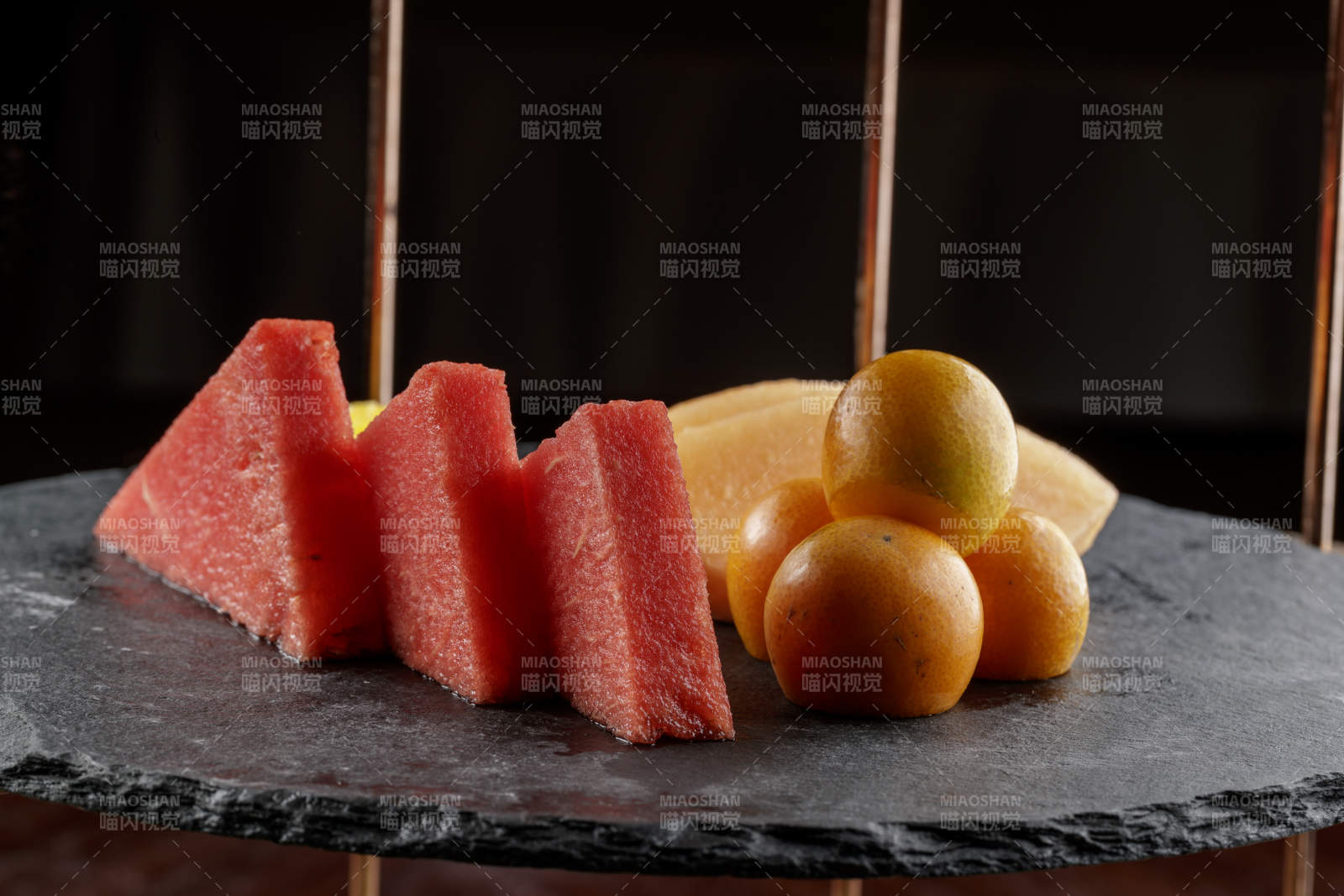 圆形黑色石板装的甜品全拼摆放在黑色背景上