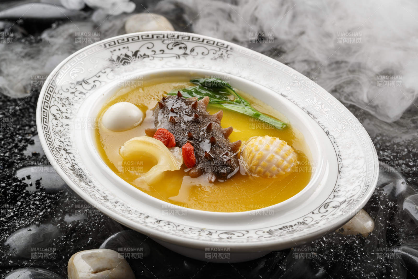 小米炖辽参摆放在黑色鹅卵石上-摄影图