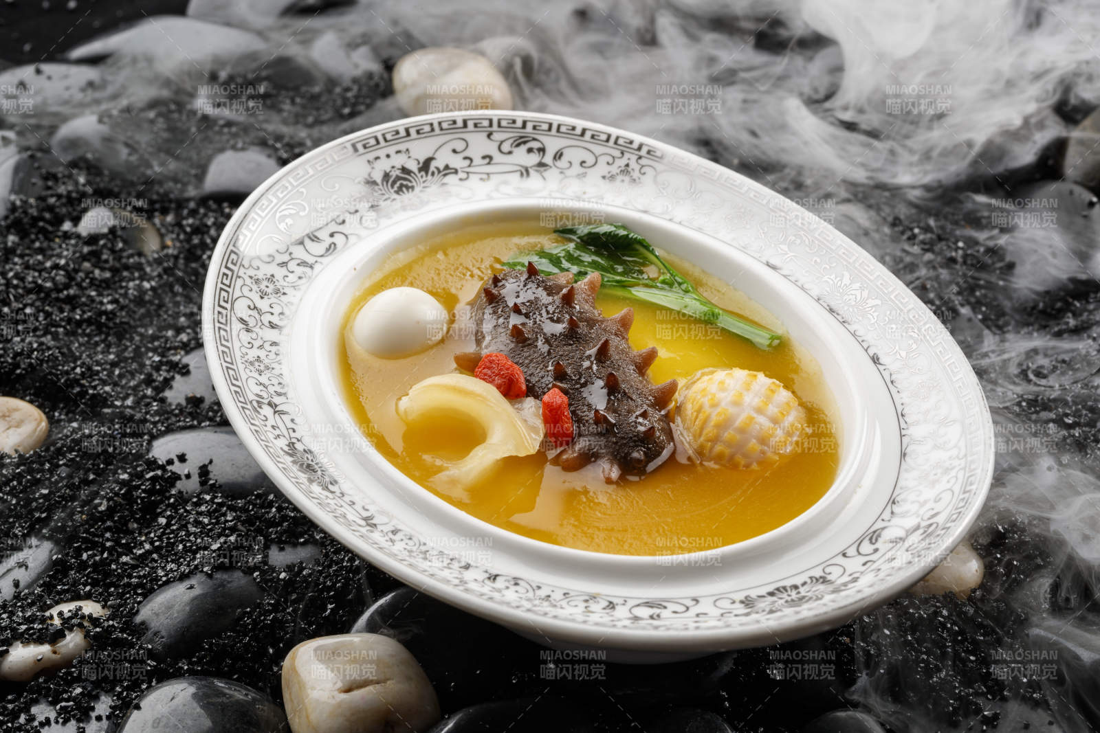 小米炖辽参摆放在黑色鹅卵石上-摄影图