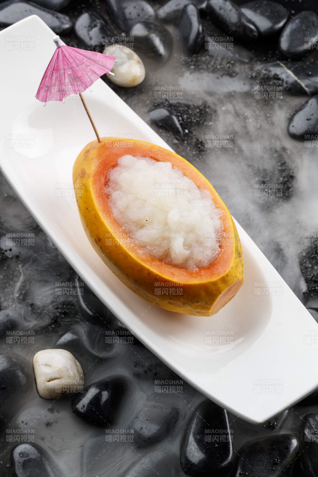 木瓜燉雪蛤擺放在干冰繚繞的鵝卵石上