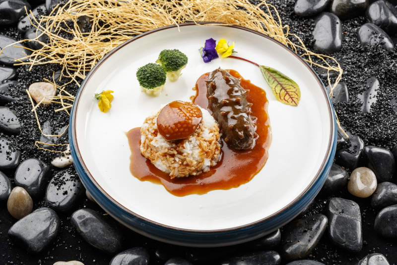鮮鮑魚(yú)遼參撈飯擺放在黑色鵝卵石上
