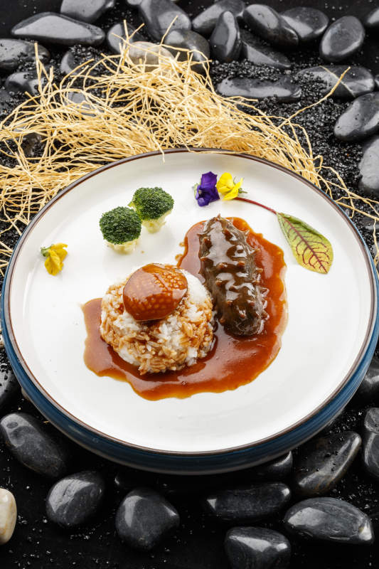 鮮鮑魚(yú)遼參撈飯擺放在黑色鵝卵石上