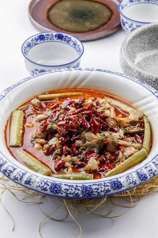 青花瓷盤裝的湘味饞嘴蛙擺放在白色底板上