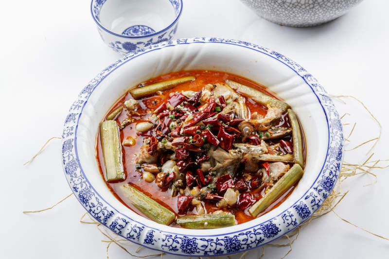 青花瓷盤裝的湘味饞嘴蛙擺放在白色底板上