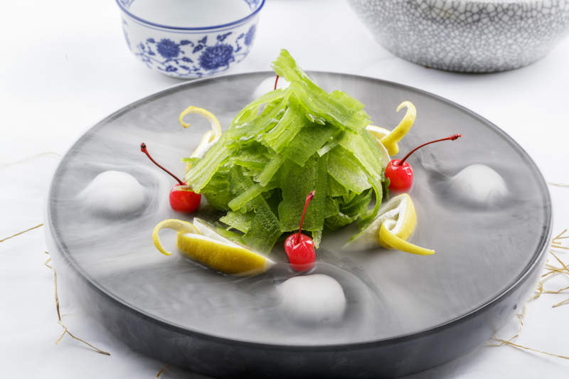 冰镇养生凉瓜摆放在干冰缭绕的黑色食盘上图片