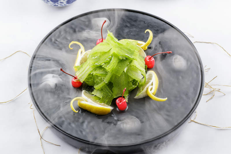 冰镇养生凉瓜摆放在干冰缭绕的黑色食盘上图片