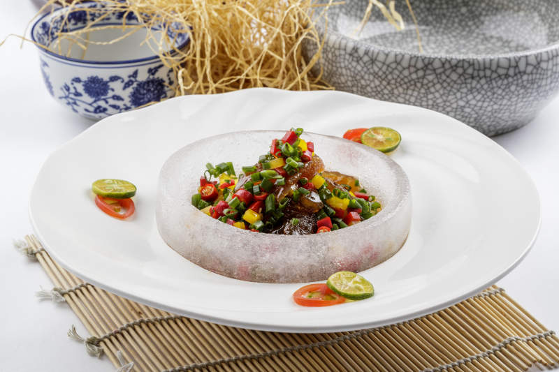 白色瓷盘装的老醋蛰头摆放在寿司帘上-摄影图