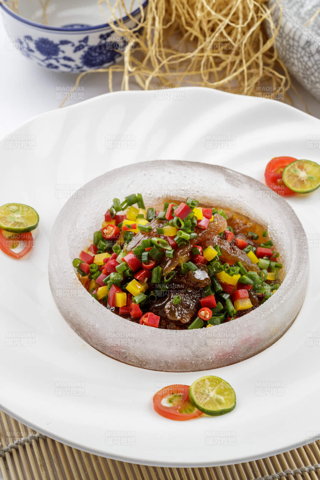 白色瓷盘装的老醋蛰头摆放在寿司帘上-摄影图