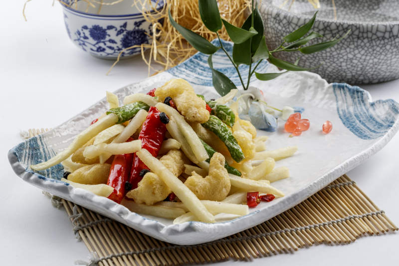 花紋瓷盤(pán)裝的虎皮雙椒薯香蒜香肉擺放在壽司簾上