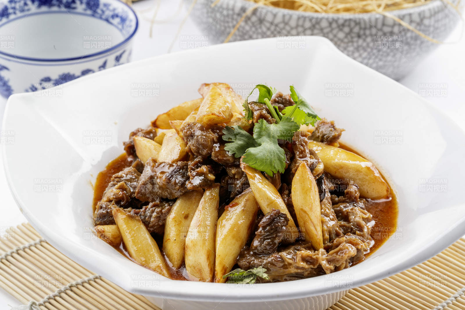 方形瓷盘装的长山药炖牛腩摆放在寿司帘上