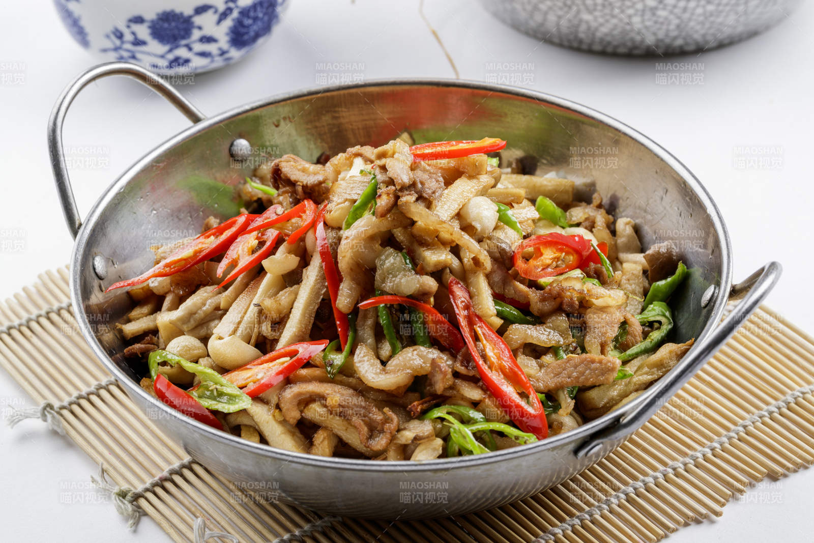 铁锅装的干锅山珍菌摆放在寿司帘上-摄影图