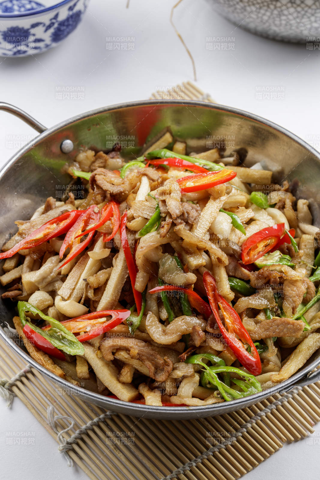 铁锅装的干锅山珍菌摆放在寿司帘上-摄影图