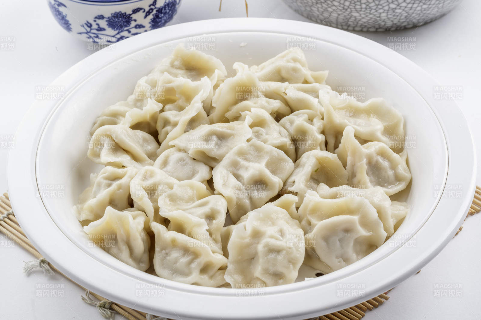 刚出锅的猪肉大葱饺子摆放在白色背景上