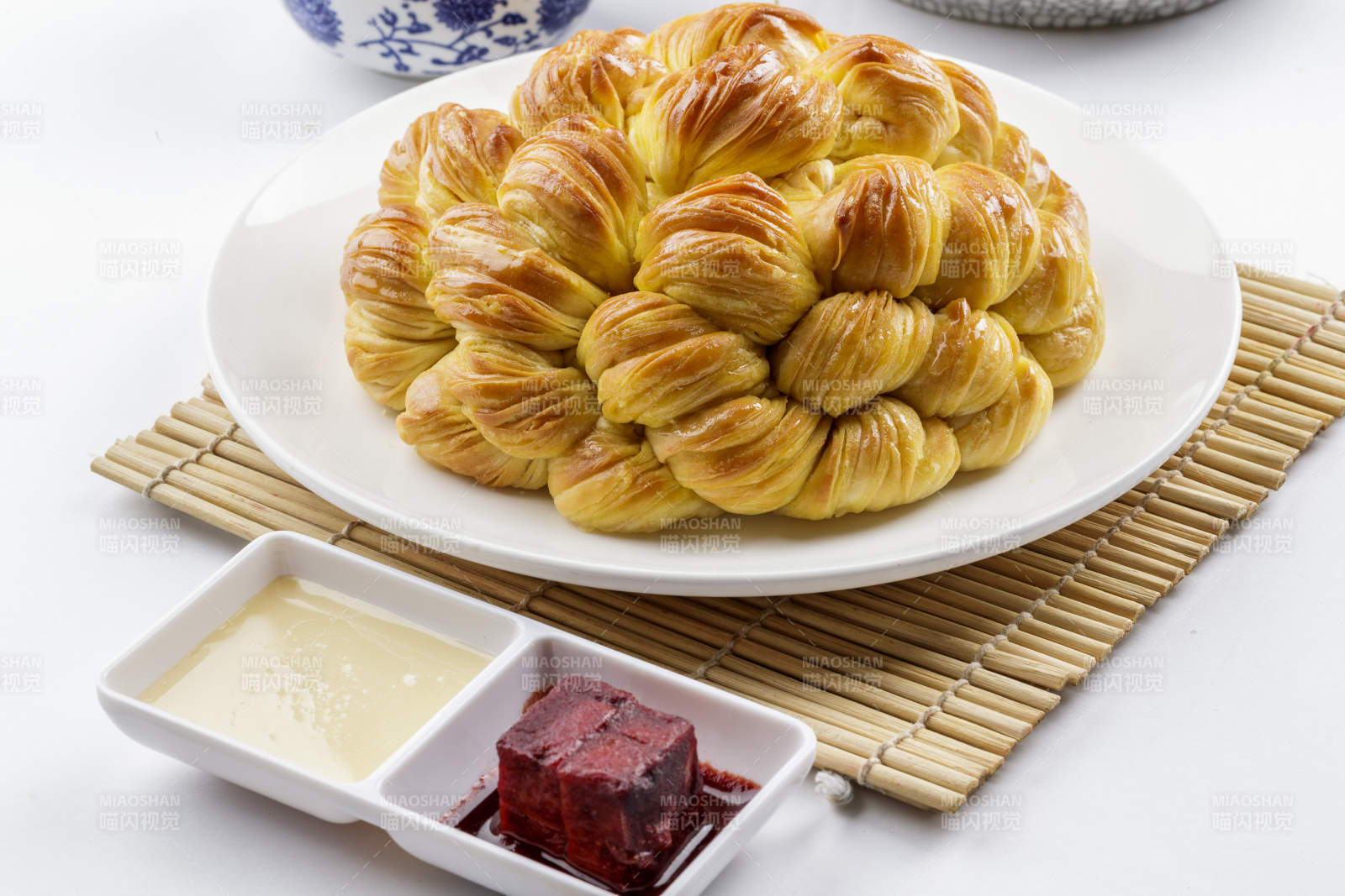 白色圓形瓷盤裝的麻油大花卷
