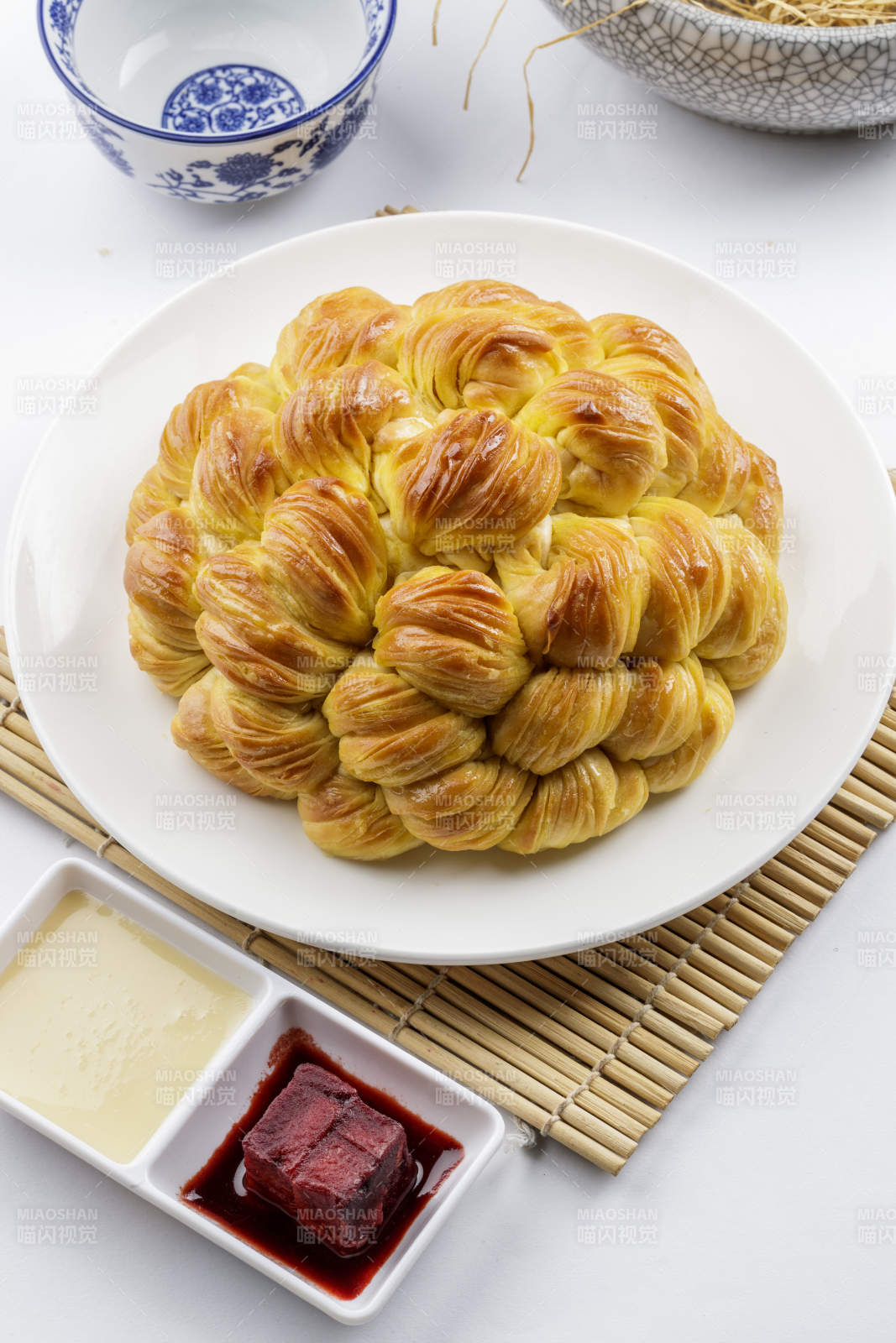白色圓形瓷盤裝的麻油大花卷