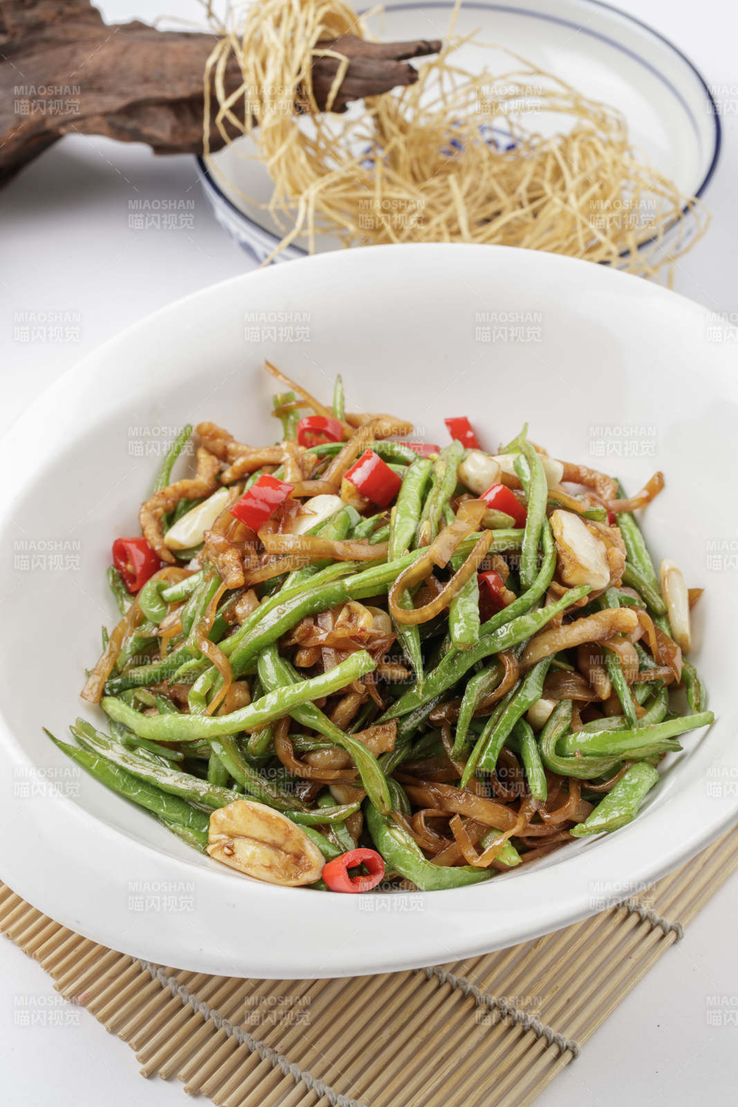 寿司帘上的元宝瓷盘装的黄花豇豆炒肉丝