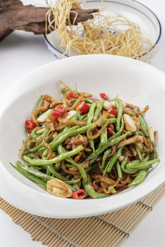 寿司帘上的元宝瓷盘装的黄花豇豆炒肉丝