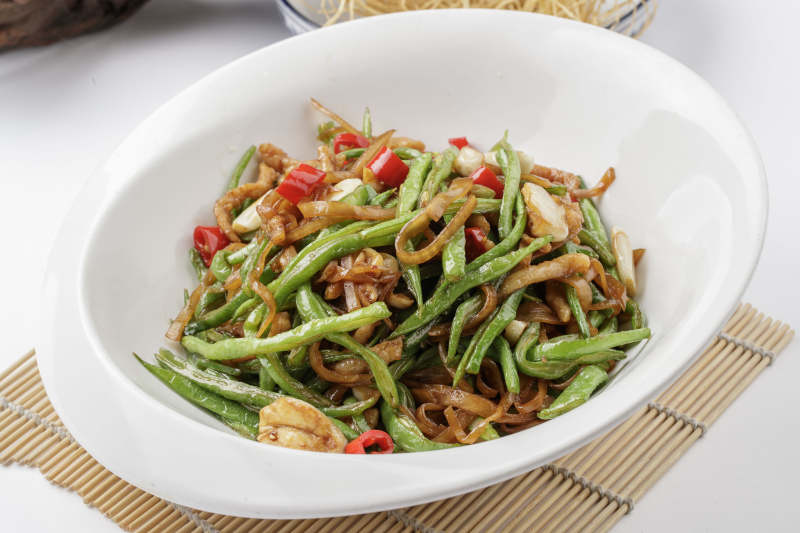 寿司帘上的元宝瓷盘装的黄花豇豆炒肉丝