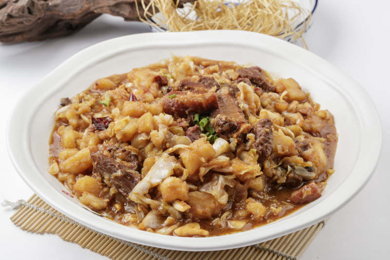 寿司帘上的环纹瓷盘装的一品乱炖