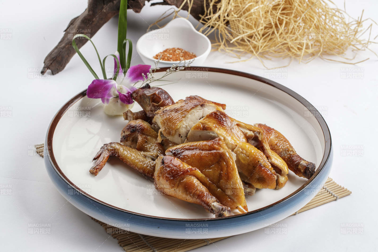 寿司帘上的圆瓷盘装的香酥脆皮鸡