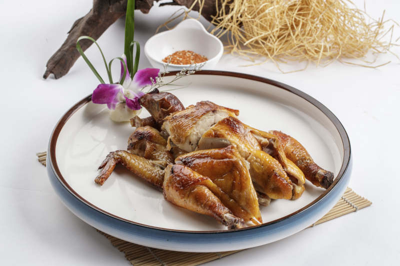 寿司帘上的圆瓷盘装的香酥脆皮鸡