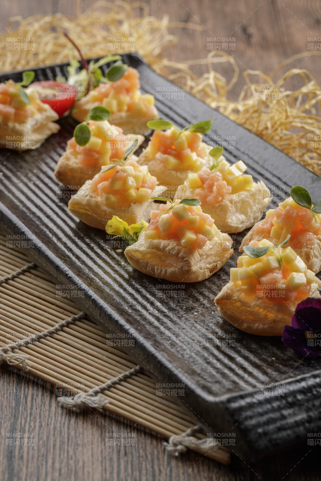 黑色长瓷盘装的芒果虾仁酥