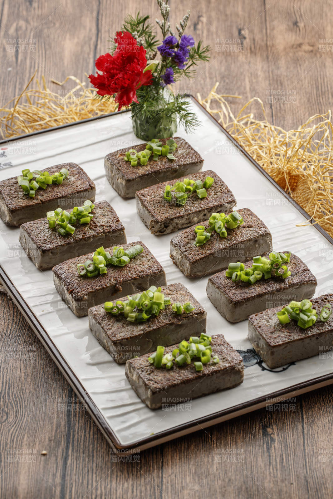 木纹底板上的长瓷盘装的香煎麻豆腐