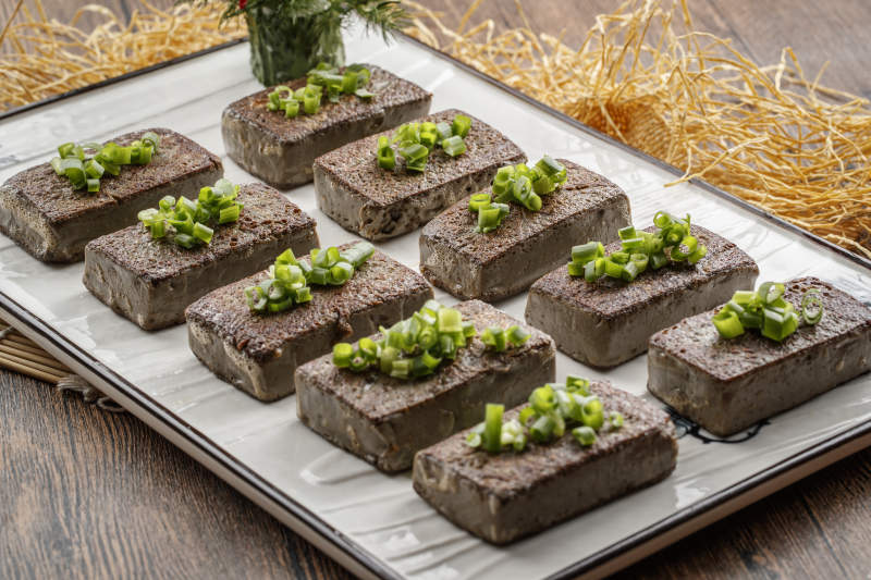 木纹底板上的长瓷盘装的香煎麻豆腐