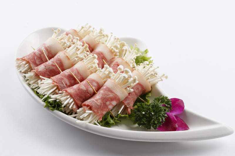 刀形瓷盤裝的金針菇培根卷