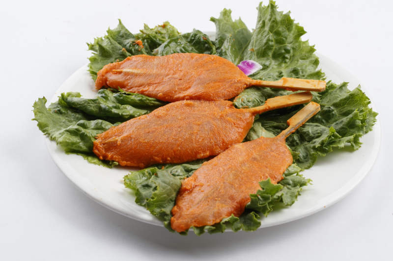 圓形白瓷盤裝的腌制雞胸串