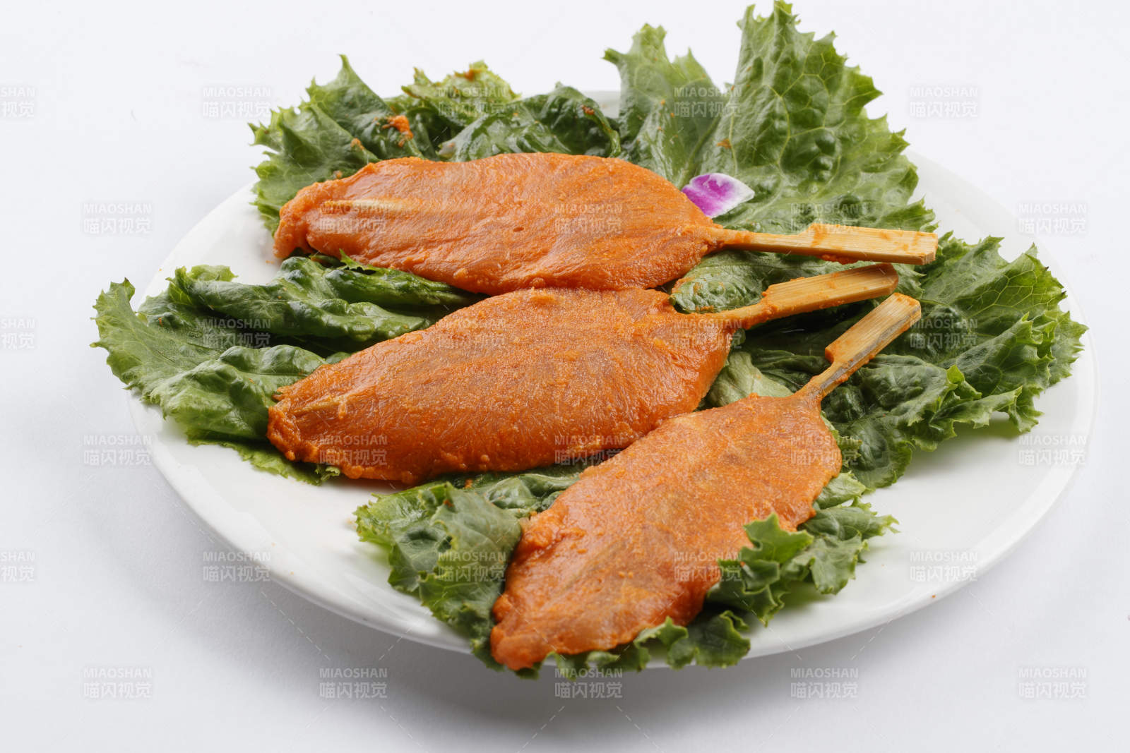 圓形白瓷盤裝的腌制雞胸串