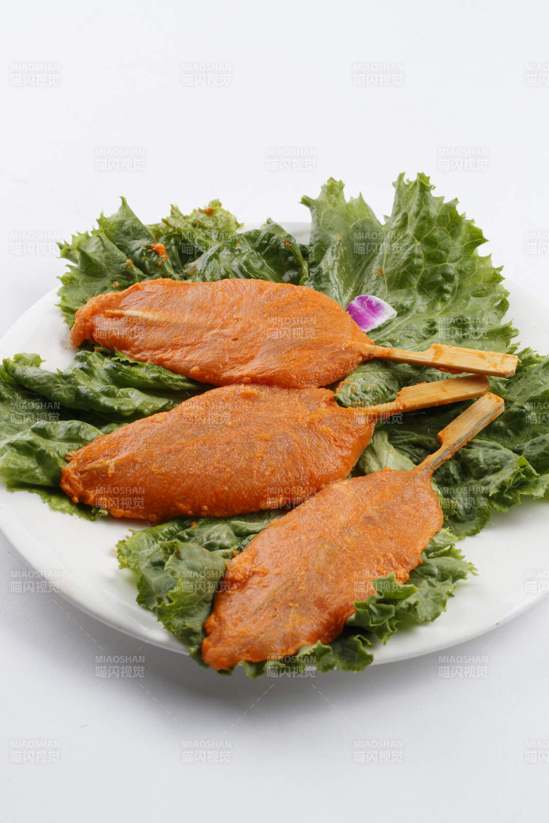 圓形白瓷盤裝的腌制雞胸串