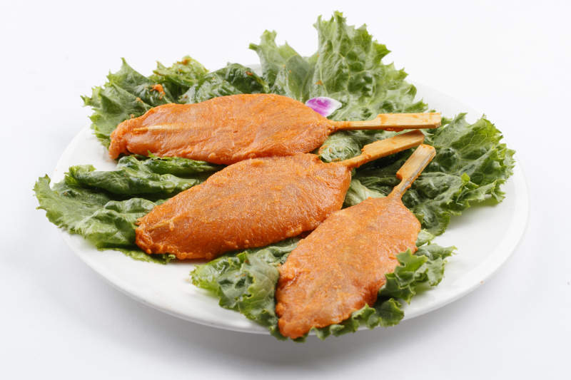 圓形白瓷盤裝的腌制雞胸串