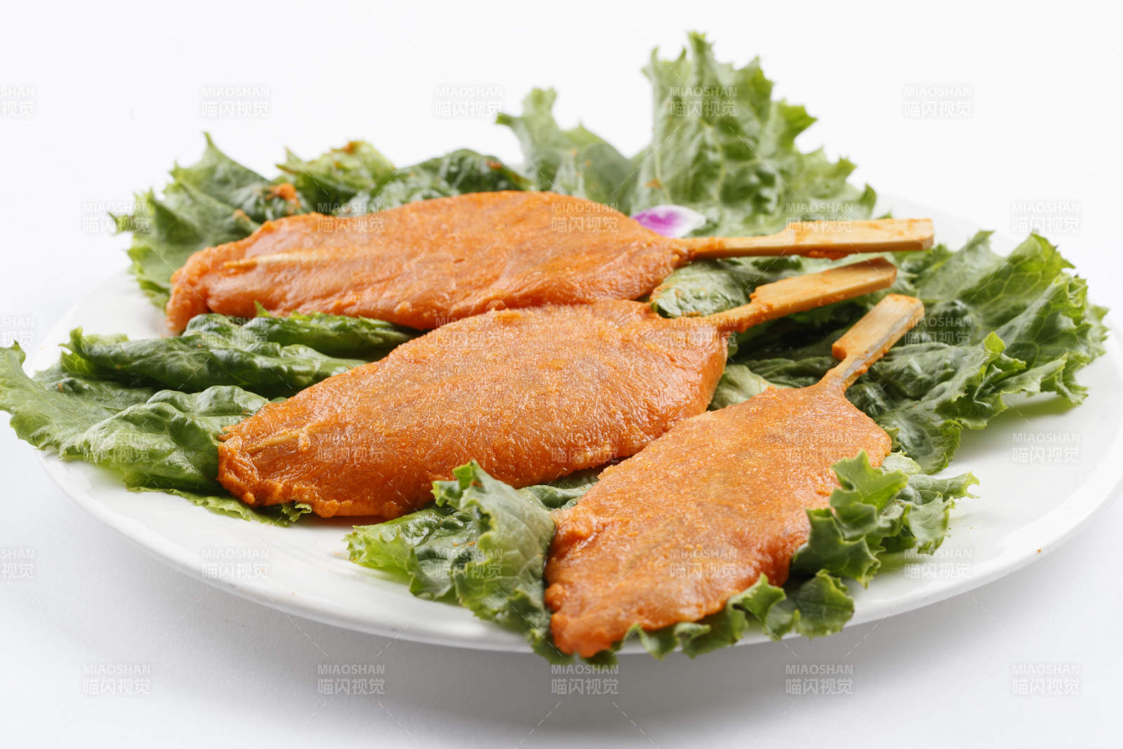 圓形白瓷盤裝的腌制雞胸串