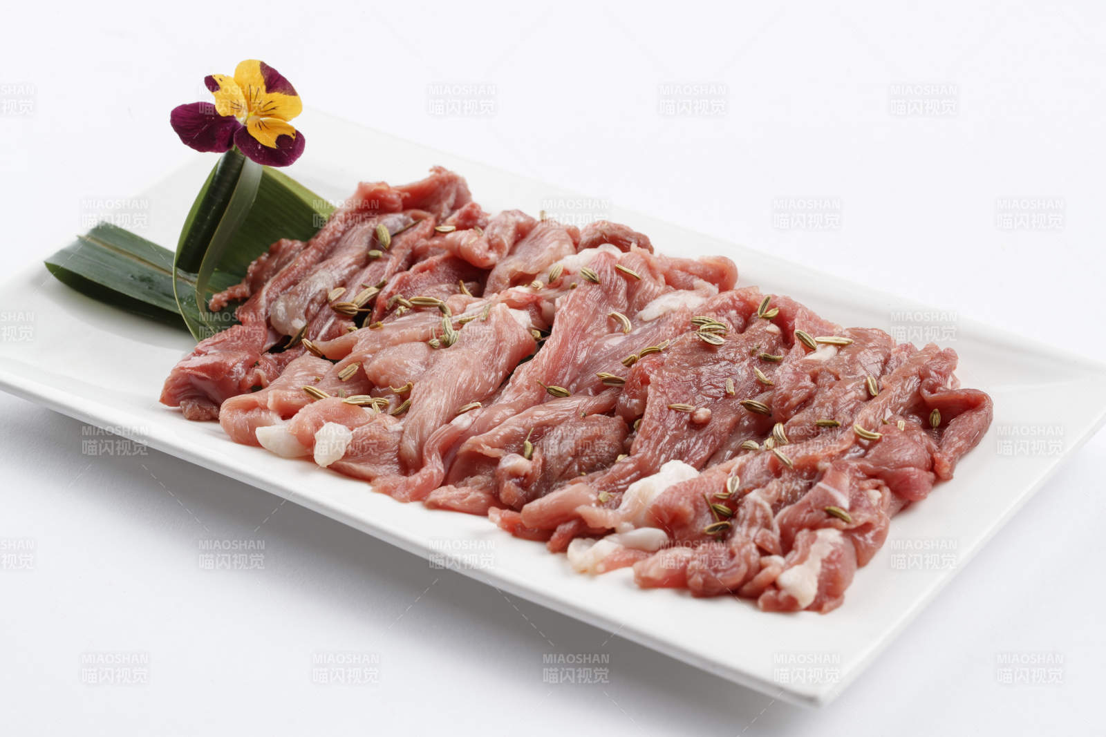 长方形白瓷盘装的鲜切羊后腿肉-摄影图