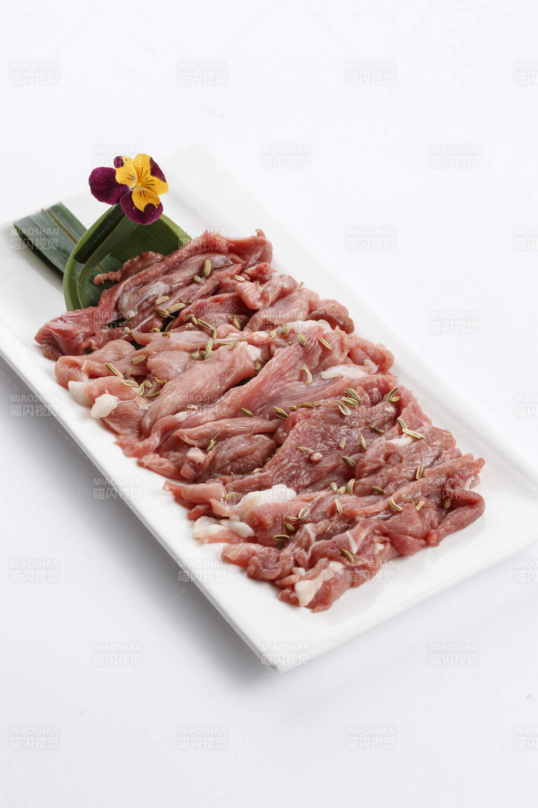 长方形白瓷盘装的鲜切羊后腿肉-摄影图