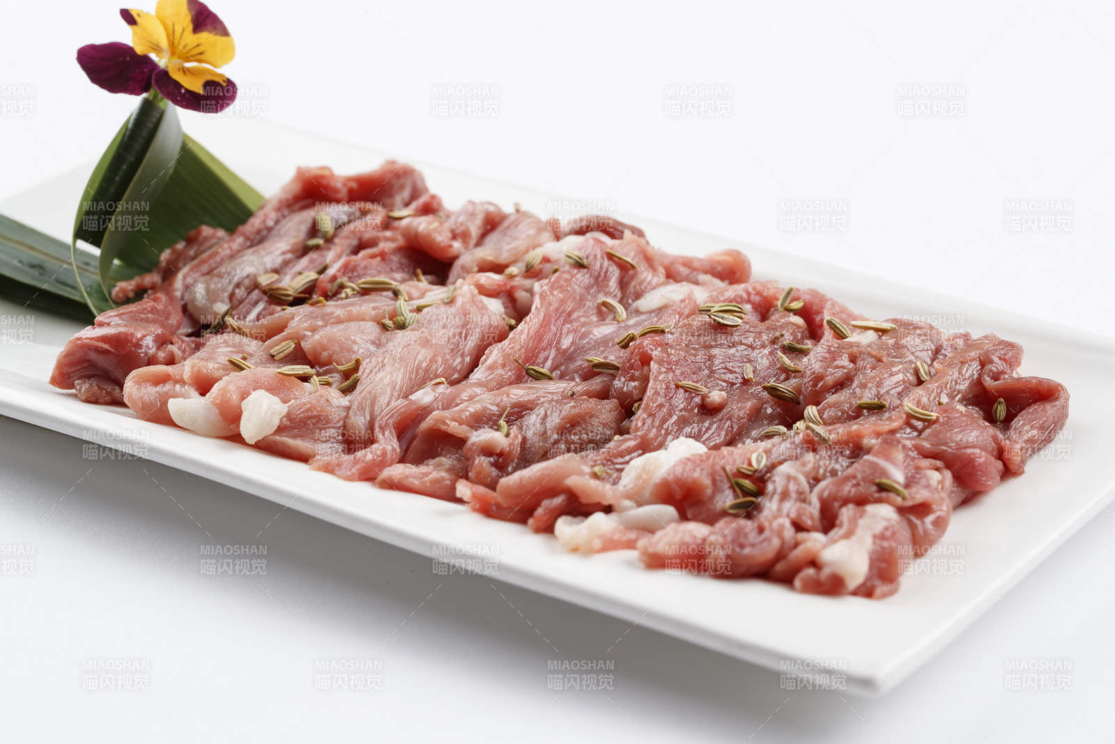 长方形白瓷盘装的鲜切羊后腿肉-摄影图