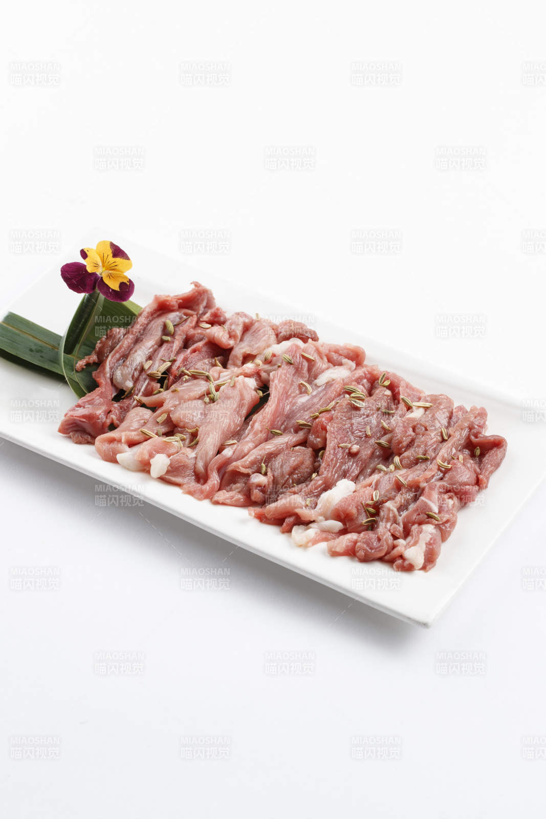 长方形白瓷盘装的鲜切羊后腿肉-摄影图