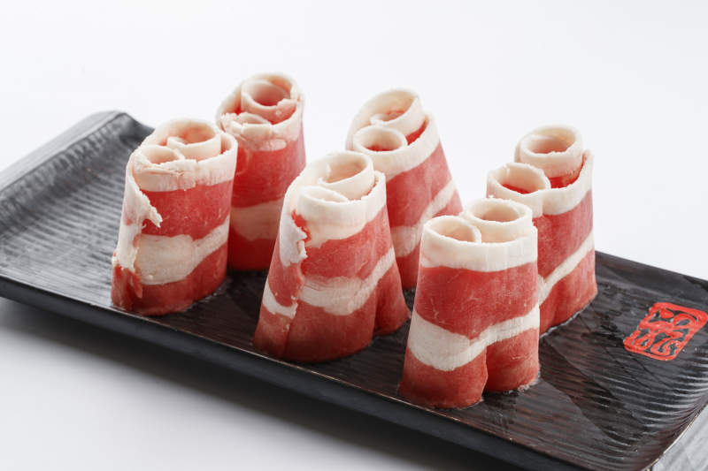 長方形黑色瓷盤裝的羊五花卷