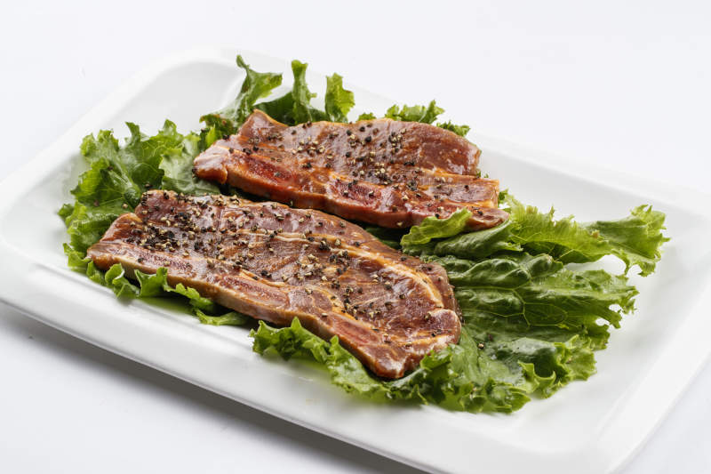 長(zhǎng)方形白瓷盤(pán)裝的黑胡椒腌制牛排肉