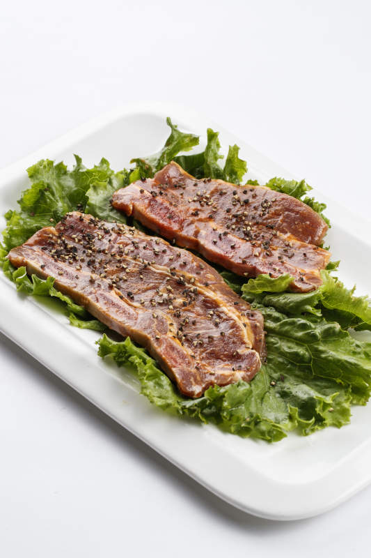 長(zhǎng)方形白瓷盤(pán)裝的黑胡椒腌制牛排肉